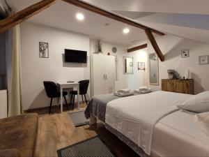 a bedroom with a bed and a table and a desk at Rooms Garden in Slunj