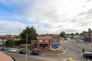 a city street with cars parked in front of a building at Large 4-Bedrooms Corporate Flat, Free Parking - Amazing Location in Leavesden Green +19 photos