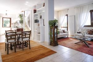 a dining room and living room with a table and chairs at Casa di Rita in Morlupo