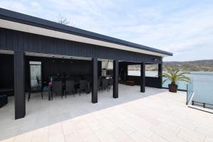 a black building with a patio with tables and chairs at BlueMaria in Eşelniţa