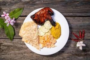 a white plate with food on a wooden table at Green Peak Resorts in Baitarāni