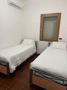 two beds sitting next to each other in a room at max piedigrotta in Pizzo +2 photos