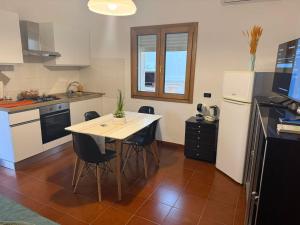 a kitchen with a table and chairs and a refrigerator at max piedigrotta in Pizzo