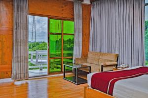 a bedroom with a bed and a chair and a window at Green Peak Resorts in Baitarāni