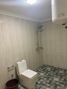 a bathroom with a white toilet and a shower at Egel Appartement in Yaoundé