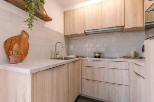 a kitchen with wooden cabinets and a sink at Casiola - Cosy apartment with vintage interior in De Haan