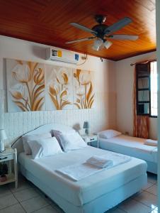 a bedroom with two beds and a ceiling fan at Casa Arcia in Rivas