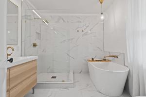 a white bathroom with a tub and a sink at Entertainer - Brookside Walkable Firepit in Kansas City +42 photos