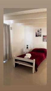 a bedroom with a large bed with a red blanket at Departamento 3 ambientes-Paseo Plaza in Navarro