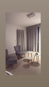 a living room with two chairs and a table at Departamento 3 ambientes-Paseo Plaza in Navarro