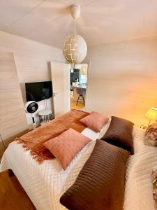 a bedroom with a large bed with pillows on it at Hills Cottage Holiday Homes in Gränna
