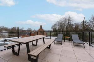 a wooden picnic table and chairs on a balcony at Casiola - Apartment with two large terraces in Zedelgem