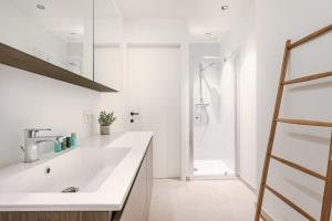 a white bathroom with a sink and a shower at Casiola - Apartment with two large terraces in Zedelgem