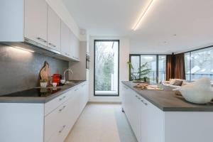 a kitchen with white cabinets and a counter top at Casiola - Apartment with two large terraces in Zedelgem