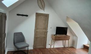 a room with a door and a chair and a television at Bed and Breakfast au calme in Avoise