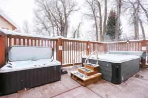 two hot tubs on a deck with a fence at Upscale Couple's Getaway Hot Tubs in Driggs