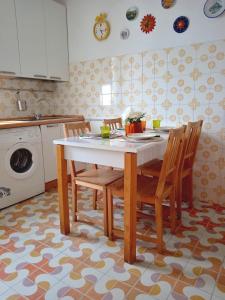a kitchen with a table with chairs and a washing machine at Suite Fronte Mare Senigallia- Terrazza Esclusiva sulla Spiaggia in Senigallia
