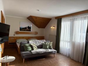 a living room with a couch and a bed at Pferdehof Rupitsch - Haus Carina in Weissensee