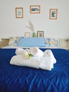 a blue bed with towels and flowers on it at Suite Fronte Mare Senigallia- Terrazza Esclusiva sulla Spiaggia in Senigallia