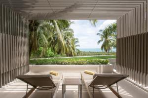 a room with a table and chairs and a large window at Mantra Samui Resort - Adults Only in Mae Nam
