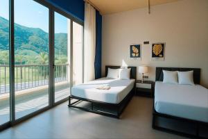 a bedroom with two beds and a large window at Sonasea Vân Đồn - Centraltique Seaside in Quang Ninh