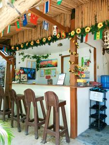 a bar in a restaurant with wooden stools at Aquing's Place in El Nido