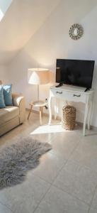 a living room with a television and a white desk at Quintinha do Quintas in Valhascos