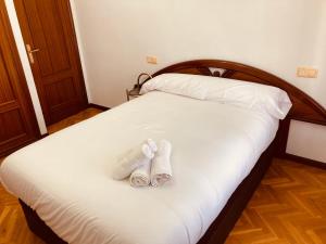 two pairs of slippers sitting on top of a bed at La Florida 43 in Soria