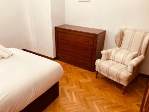a bedroom with a bed and a chair and a dresser at La Florida 43 in Soria +7 photos