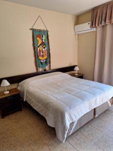 a bedroom with a bed and a painting on the wall at Pontal Tapes Hotel in Tapes