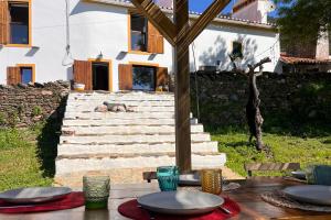 a table with plates on it in front of a house at Casa da Vinagra in Pé da Serra +72 photos