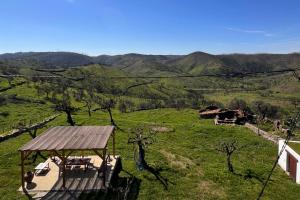 a gazebo in a field with mountains in the background at Casa da Vinagra in Pé da Serra