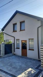 a white house with a door and a driveway at Garage Home in Yaremche