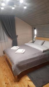a bedroom with a bed with two towels on it at Garage Home in Yaremche
