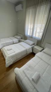 a room with four beds and a window at Hotel RADOJA in Shkodër