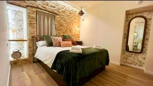 a bedroom with a bed and a large mirror at Arrels Terra - Apartamento boutique mediterráneo in L'Ampolla