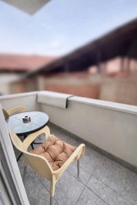a small table and a chair on a balcony at N&M Apartment in Pirot