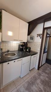 a kitchen with white cabinets and a sink at Ferienwohnung Schäfer in Siegsdorf