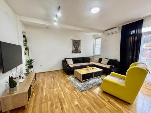 a living room with a couch and a tv at N&M Apartment in Pirot