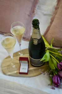 a bottle of champagne and two glasses on a tray at Le Cocon Spa proche Puy DuFou in Mesnard-la-Barotière