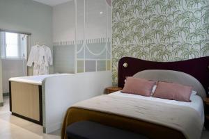 a bedroom with a bed with a headboard and wallpaper at Le Cocon Spa proche Puy DuFou in Mesnard-la-Barotière +24 photos