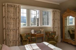 a bedroom with a bed and a mirror and a window at Windlestraw Guesthouse in Walkerburn