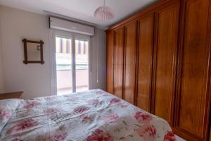 a bedroom with a bed and a wooden cabinet at Casa Turistica Andora in Marina di Andora