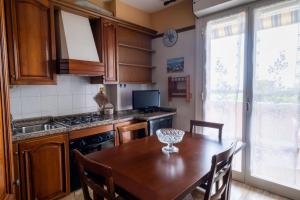 a kitchen with a wooden table with chairs and a dining room at Casa Turistica Andora in Marina di Andora +7 photos