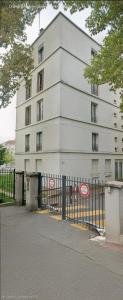 a white building with a black fence in front of it at Séjour Eau Vive Proche commerces et Metro in Créteil