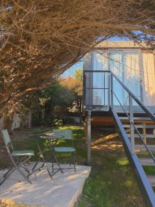 a house with a table and chairs on the grass at Bungalow da Romy in Vila Praia de Âncora