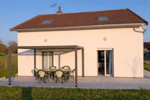 a patio with a table and chairs in front of a building at Maison de campagne in Souvans