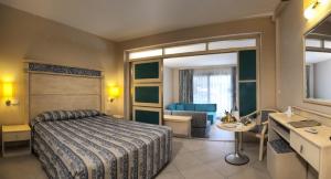 a hotel room with a bed and a bathroom at Ephesia Holiday Beach Club in Kuşadası