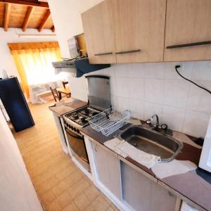 a kitchen with a sink and a stove top oven at Alquiler por Día SyA Cipolletti in Cipolletti