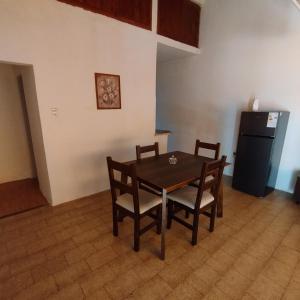 a dining room with a table and chairs and a refrigerator at Alquiler por Día SyA Cipolletti in Cipolletti